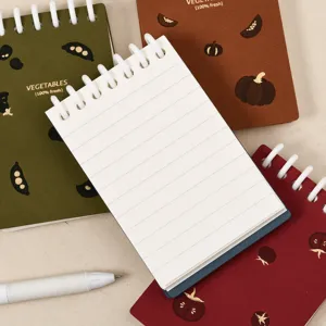 Mini taccuino a spirale tascabile con motivi di verdure e pagine rigate per uso quotidiano.