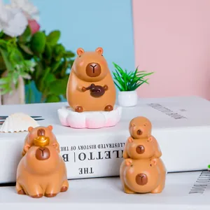 Gedetailleerde macro-weergave van drie schattige hars capibara-beeldjes op witte decoratieve boeken