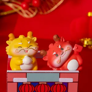 Close-up of two cute cartoon dragon resin figurines in festive red and yellow colors.