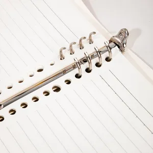 Loose leaf notebook detail showing metal binder rings and lined paper for study work.
