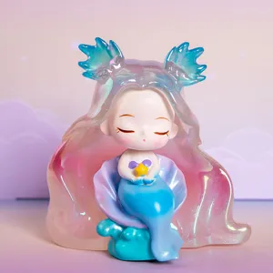 Dettaglio macro che mostra la statuina di sirena elfo sognante in resina iridescente.