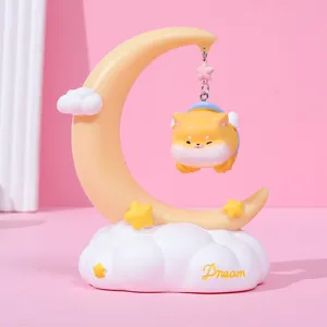 Detail of a cute shiba inu figurine hanging from a crescent moon fairy tale night light