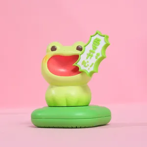 Detail view of a green screaming frog resin figurine fragrance box on a pink background