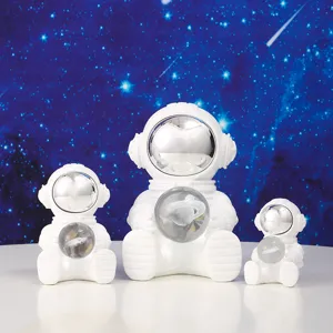 Detail of three white astronaut night light figurines with celestial crystal balls