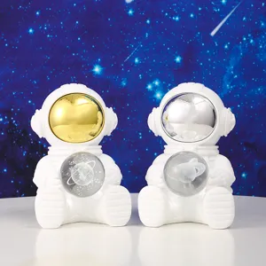 Detail showing two astronaut night light figurines with gold and silver visors