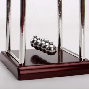 Vista detallada de cinco bolas de acero inoxidable pulido en un péndulo de Newton de escritorio