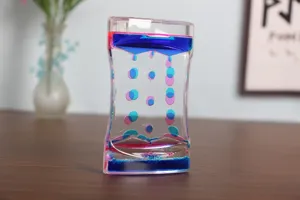 Soothing liquid motion bubbler timer with blue and pink oil drops on a wooden desk