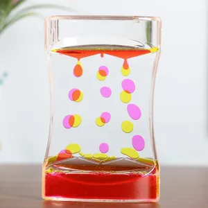 Detail of colorful dual-color oil droplets falling in a waist-shaped liquid motion bubbler