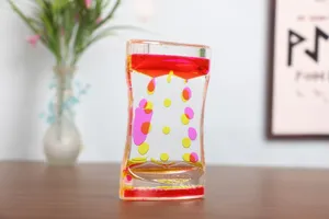 Detailed view of double colored pink and yellow liquid motion bubbler timer on a wooden desk