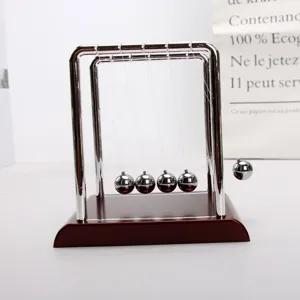 Detalle de las bolas metálicas del péndulo de Newton en movimiento sobre base