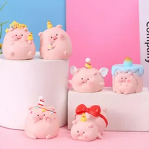 Detailed view of cute pink resin pig figurines with various colorful party decorations.