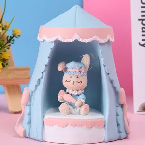 Gros plan d'une figurine de lapin en résine dans un ornement de tente bleu et rose