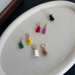 Dettaglio di orecchini a cerchio con orsetti di resina colorati e zirconi scintillanti.