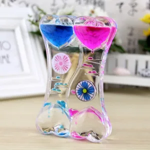 Detaillierte Makroansicht der herzförmigen Flüssigkeits-Sanduhr mit rosa blauen Tropfen.