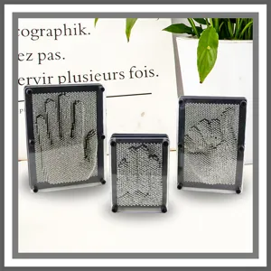 Display of three different sizes of 3D pin impression art toys with hand clone designs