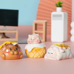 Primer plano de tres figuras de gatos iridiscentes con temática de comida gourmet