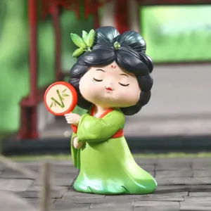 Detail view of cute Tang Dynasty style resin girl figurine with green dress and fan