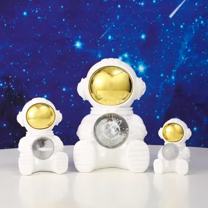Three astronaut night light figurines with crystal galaxy balls in different sizes.