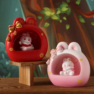 Detail of two cute bunny resin night light ornaments placed on a rustic wooden stand