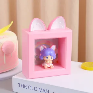 Detalle de una linda figura de resina dentro de un organizador de escritorio rosa con orejas de gato