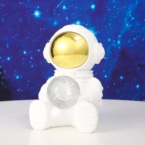 Detail view of a white astronaut night light holding a crystal planet ball for bedside decor.
