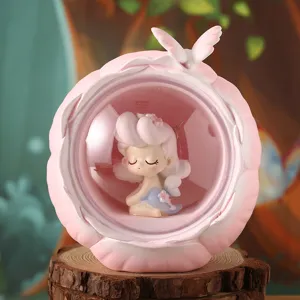 Close-up of a cute girl figurine inside a pink resin night light ornament on a wood stump.