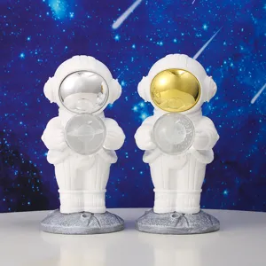 Macro detail view of two cute astronaut night light figurines with gold and silver visors