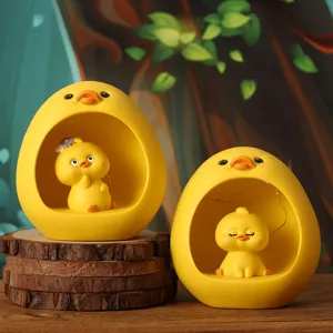 Detailed view of two cute yellow duck resin ornaments placed on a natural wooden slice
