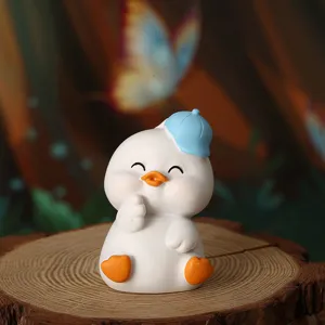 Cute white duck figurine with blue cap on rustic wood slice for home desk decor ornament