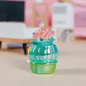 Vista detallada de una figurita de elfo de resina con decoración de loto rosa