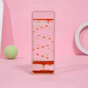 Detalle de temporizador de líquido creativo con gotas rojas y verdes sobre rosa