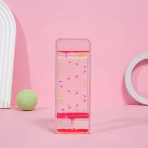 Detalle de un reloj de arena líquido creativo con gotas rosas y amarillas cayendo