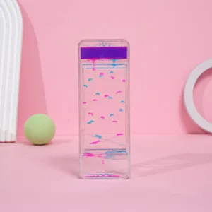 Detalle de un creativo reloj de arena líquido con gotas de color púrpura y rosa