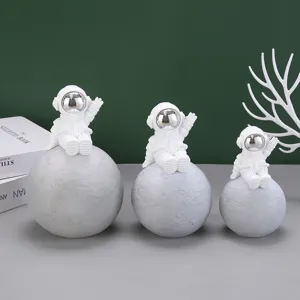 Gruppo di figurine di astronauti in resina bianca su pianeti lunari come lampade decor