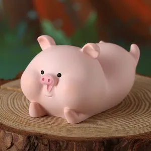 Primo piano di una simpatica statuina di maiale rosa in resina su un ceppo di legno naturale.