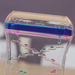 Gros plan détaillé sur des gouttes d'huile bleues et roses dans un sablier liquide