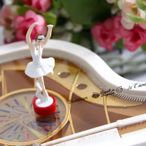 Detailed close-up of a white piano music box with an elegant rotating ballerina figurine.