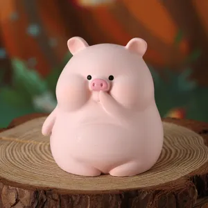 Dettaglio di una graziosa statuina di maiale rosa in resina su base naturale.