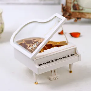 Detail of white grand piano music box with Piano Recital engraving and gold floral pattern