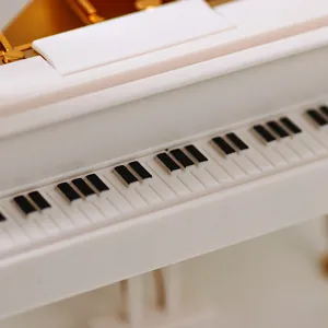 Macro view showing the detailed white and black keys of a grand piano music box model