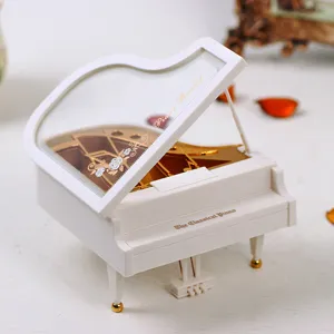 Detailed view of a white miniature grand piano music box with elegant gold accents
