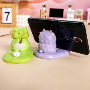 Vue détaillée d'un support de téléphone mignon en résine grenouille en méditation