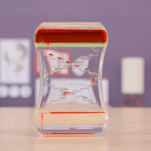 Gros plan d'un sablier à liquide bicolore comme jouet de bureau relaxant