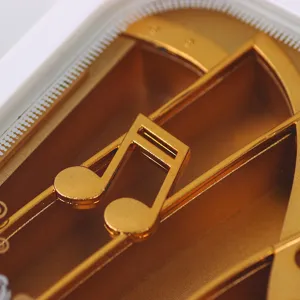 Detailed macro shot of elegant golden musical notes inside a piano-shaped wind-up music box.