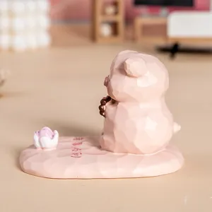 Vue latérale du support de téléphone mignon cochon en résine rose avec base lotus