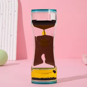 Vista macro de un reloj de arena de líquido bicolor con gotas amarillas y marrones