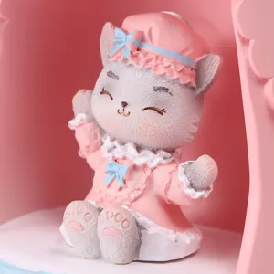 Vue détaillée d'une figurine de chat mignonne portant une robe rose et nœuds bleus
