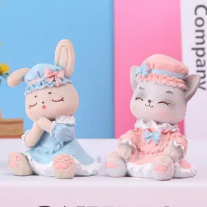 Détail de figurines mignonnes de lapin et de chat en tenues pastel bleues et roses