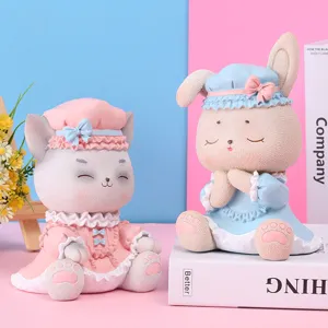 Détail de mignonnes figurines de chat et lapin en résine avec tenues à volants pastels