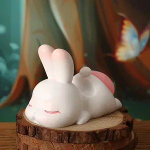 Cute resin rabbit phone holder figurine on a rustic wooden slice base for desk decor